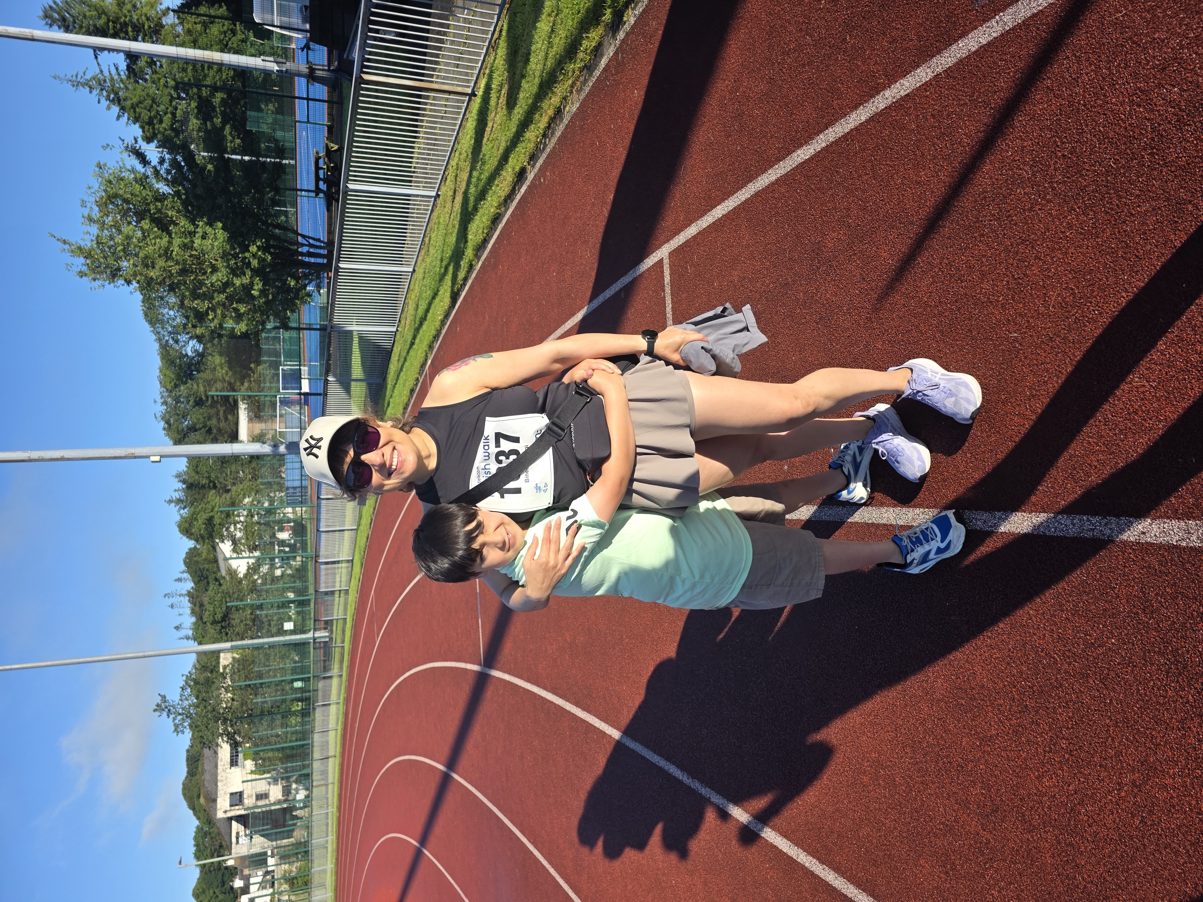 Bineeta and her son Luke embracing on the running track before the Parish Walk